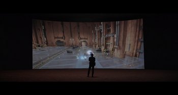 Movie still from “Obi-Wan Kenobi: A Jedi's Return” (2022), directed by David Gelb – A man standing in front of a large projection screen; Wide shot, High angle