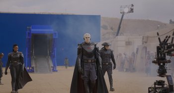 Movie still from “Obi-Wan Kenobi: A Jedi's Return” (2022), directed by David Gelb – Two men in costumes are walking in the sand; Wide shot, Over the shoulder angle