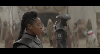 Movie still from “Obi-Wan Kenobi: A Jedi's Return” (2022), directed by David Gelb – A woman in a black outfit and a man in a black outfit; Close Up shot, Over the shoulder angle