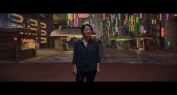 Movie still from “Obi-Wan Kenobi: A Jedi's Return” (2022), directed by David Gelb – A woman standing in front of a neon sign; Wide shot, Over the shoulder angle