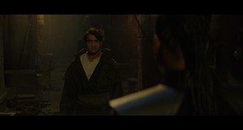 Movie still from “Obi-Wan Kenobi: A Jedi's Return” (2022), directed by David Gelb – A man wearing a robe and a hat is looking into a mirror; Medium shot, Over the shoulder angle