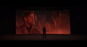 Movie still from “Obi-Wan Kenobi: A Jedi's Return” (2022), directed by David Gelb – A man standing in front of a projection screen; Extreme Wide shot, Over the shoulder angle
