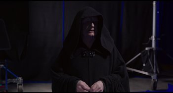 Movie still from “Obi-Wan Kenobi: A Jedi's Return” (2022), directed by David Gelb – An old man dressed in a black robe and a black hood; Medium shot, Low angle
