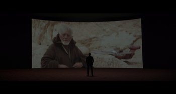 Movie still from “Obi-Wan Kenobi: A Jedi's Return” (2022), directed by David Gelb – A man standing in front of a projection screen; Wide shot, Over the shoulder angle