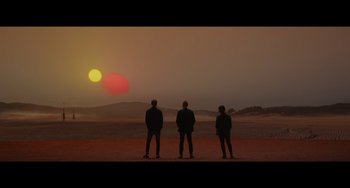 Movie still from “Obi-Wan Kenobi: A Jedi's Return” (2022), directed by David Gelb – Three people standing in front of a sunset; Wide shot, Low angle