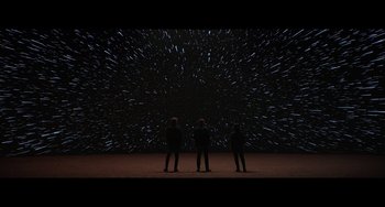 Movie still from “Obi-Wan Kenobi: A Jedi's Return” (2022), directed by David Gelb – Three people are standing in front of a star field; Extreme Wide shot, Low angle