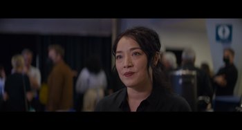 Movie still from “Obi-Wan Kenobi: A Jedi's Return” (2022), directed by David Gelb – A woman in a black shirt is looking at the camera; Close Up shot, Over the shoulder angle