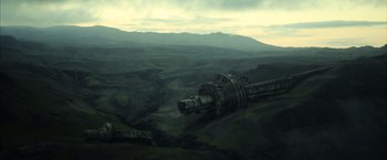 Movie still from “Oblivion” (2013), directed by Joseph Kosinski – An abandoned military vehicle in the middle of a green valley; Extreme Wide shot, High angle