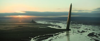Movie still from “Oblivion” (2013), directed by Joseph Kosinski – A view from a plane of a body of water with a lighthouse in the background; Extreme Wide shot, Low angle