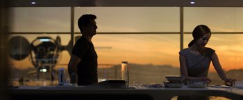 Movie still from “Oblivion” (2013), directed by Joseph Kosinski – A man standing in front of a window at sunset; Medium shot, Low angle