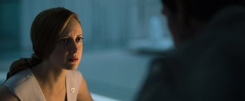 Movie still from “Oblivion” (2013), directed by Joseph Kosinski – A woman sitting in front of a man in a room; Close Up shot, Over the shoulder angle