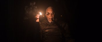Movie still from “Oblivion” (2013), directed by Joseph Kosinski – An older man holding a lit candle in a dark room; Close Up shot, Low angle