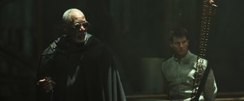 Movie still from “Oblivion” (2013), directed by Joseph Kosinski – An older man wearing a black cape and sunglasses; Medium shot, Low angle