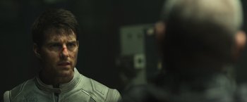 Movie still from “Oblivion” (2013), directed by Joseph Kosinski – A man in a white suit is looking at the camera; Close Up shot, Over the shoulder angle