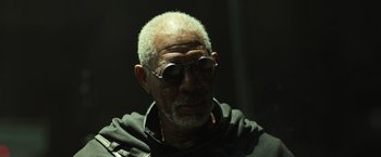 Movie still from “Oblivion” (2013), directed by Joseph Kosinski – An older man wearing sunglasses and a black jacket; Close Up shot, Low angle