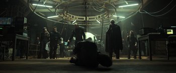 Movie still from “Oblivion” (2013), directed by Joseph Kosinski – A group of people standing in a room; Wide shot, Over the shoulder angle