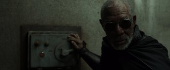 Movie still from “Oblivion” (2013), directed by Joseph Kosinski – An older man wearing sunglasses and a black shirt; Close Up shot, High angle