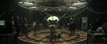 Movie still from “Oblivion” (2013), directed by Joseph Kosinski – A group of people standing in a room; Wide shot, High angle