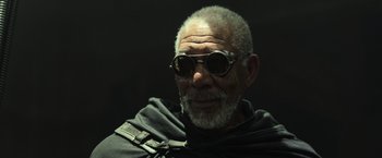 Movie still from “Oblivion” (2013), directed by Joseph Kosinski – An older man wearing sunglasses and a black shirt; Close Up shot, Low angle