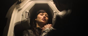 Movie still from “Oblivion” (2013), directed by Joseph Kosinski – A woman sitting on a plane looking up at the ceiling; Close Up shot, Overhead angle