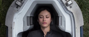 Movie still from “Oblivion” (2013), directed by Joseph Kosinski – A young woman sitting in an mri machine with her eyes closed; Close Up shot, Overhead angle