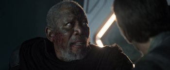 Movie still from “Oblivion” (2013), directed by Joseph Kosinski – An older man with a bloody nose and chest; Close Up shot, Over the shoulder angle