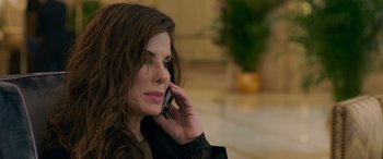 Movie still from “Ocean's Eight” (2018), directed by Gary Ross – A woman talking on a cell phone while sitting in a room; Close Up shot, High angle