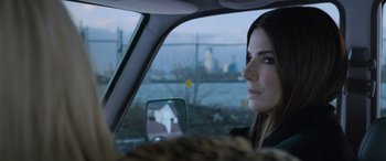 Movie still from “Ocean's Eight” (2018), directed by Gary Ross – A woman sitting in the passenger seat of a car looking out the window; Close Up shot, Over the shoulder angle