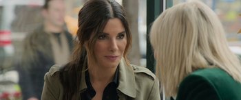 Movie still from “Ocean's Eight” (2018), directed by Gary Ross – A person wearing a trench coat; Close Up shot, Over the shoulder angle