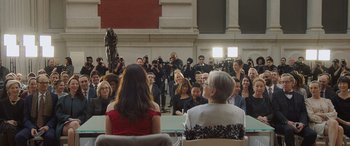 Movie still from “Ocean's Eight” (2018), directed by Gary Ross – A group of people sitting in front of an audience; Wide shot, Over the shoulder angle