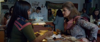 Movie still from “Ocean's Eight” (2018), directed by Gary Ross – Two women sitting at a table in a jewelry store; Medium shot, Over the shoulder angle