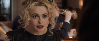 Movie still from “Ocean's Eight” (2018), directed by Gary Ross – A person with curly blonde hair; Close Up shot, Over the shoulder angle