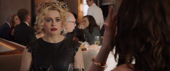 Movie still from “Ocean's Eight” (2018), directed by Gary Ross – A group of people sitting at a table with wine glasses; Close Up shot, Over the shoulder angle