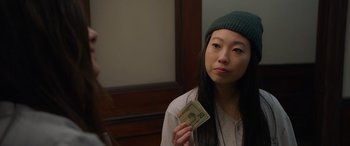 Movie still from “Ocean's Eight” (2018), directed by Gary Ross – A woman holding a twenty dollar bill in front of a mirror; Close Up shot, Over the shoulder angle