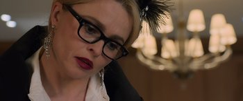 Movie still from “Ocean's Eight” (2018), directed by Gary Ross – A person wearing glasses; Close Up shot, Over the shoulder angle