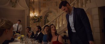 Movie still from “Ocean's Eight” (2018), directed by Gary Ross – A group of people sitting at a dinner table; Medium shot, Over the shoulder angle