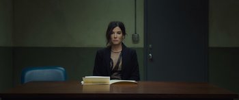 Movie still from “Ocean's Eight” (2018), directed by Gary Ross – A woman sitting at a table in front of an open book; Medium shot, High angle