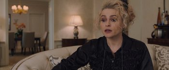 Movie still from “Ocean's Eight” (2018), directed by Gary Ross – A woman sitting on a couch in front of a lamp; Close Up shot, Over the shoulder angle