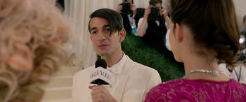 Movie still from “Ocean's Eight” (2018), directed by Gary Ross – A man in a white suit is holding a microphone; Close Up shot, Over the shoulder angle