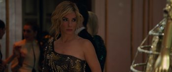 Movie still from “Ocean's Eight” (2018), directed by Gary Ross – A beautiful woman in a gold and black dress; Close Up shot, Over the shoulder angle