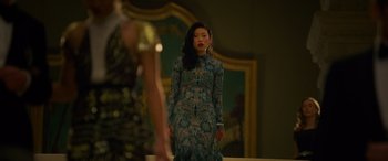 Movie still from “Ocean's Eight” (2018), directed by Gary Ross – A woman in a blue dress standing in front of a mirror; Medium shot, Over the shoulder angle