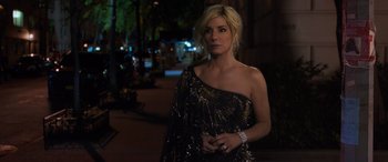 Movie still from “Ocean's Eight” (2018), directed by Gary Ross – A woman in a black and gold dress standing on a sidewalk; Close Up shot, Over the shoulder angle