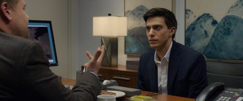 Movie still from “Ocean's Eight” (2018), directed by Gary Ross – A man sitting at a table with a plate of food in front of him; Close Up shot, Over the shoulder angle