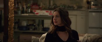 Movie still from “Ocean's Eight” (2018), directed by Gary Ross – A beautiful woman sitting on a couch in a living room; Close Up shot, Over the shoulder angle