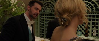 Movie still from “Ocean's Eight” (2018), directed by Gary Ross – A man and a woman sitting at a dinner table; Close Up shot, Over the shoulder angle