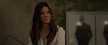 Movie still from “Ocean's Eight” (2018), directed by Gary Ross – A person wearing a white shirt; Close Up shot, Over the shoulder angle