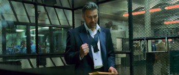 Movie still from “Ocean's Eleven” (2001), directed by Steven Soderbergh – A man wearing a suit and tie holding a wooden spoon; Medium shot, Low angle