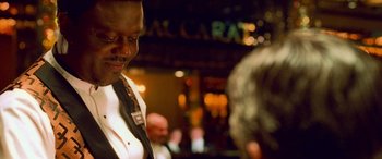 Movie still from “Ocean's Eleven” (2001), directed by Steven Soderbergh – A man standing in front of a woman in front of a sign; Close Up shot, Over the shoulder angle