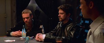 Movie still from “Ocean's Eleven” (2001), directed by Steven Soderbergh – A man sitting at a table with a glass of wine; Medium shot, Over the shoulder angle