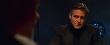 Movie still from “Ocean's Eleven” (2001), directed by Steven Soderbergh – A man in a black suit sitting in front of another man in a black suit; Close Up shot, Over the shoulder angle
